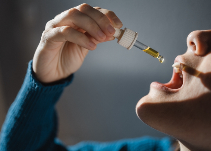 woman taking cbd tincture